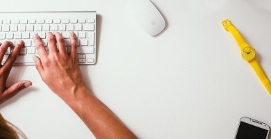 aerial-view-of-hands-on-computer-keyboards-mobile-phone-and-yellow-watch-on-table